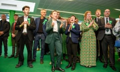 Members of the green party crowd together, clapping and cheering, after news they held a seat