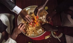 Men share a dish of pilau rice for lunch during Eid Mubarak celebrations.