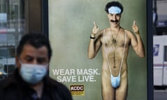 US-ENTERTAINMENT-FILM-HEALTH-VIRUS<br>A person wearing a mask walks past a bus stop ad on 5th Avenue, October 15, 2020, for the upcoming movie “Borat 2,” featuring actor Sacha Baron Cohen, ahead of its release on October 23. - The poster gives reference to the Covid-19 pandemic by replacing Borats iconic green mankini with a face mask. (Photo by TIMOTHY A. CLARY / AFP) (Photo by TIMOTHY A. CLARY/AFP via Getty Images)