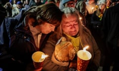 People hold candles at a vigil for the victims of a mass shooting in Lewiston, Maine.
