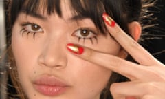 a woman with long red nails with a star painted on each tip