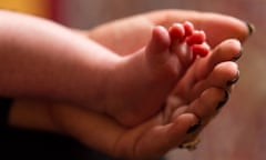 A mother holding the feet of a new baby