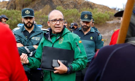 Cipriano Martin, wearing a Guardia Civil jacket and carrying a notebook, talking to a group of people