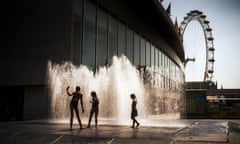 Children playing near water fountains with the london eye in the background