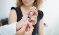 Hands with syringe near woman awaiting vaccination