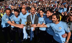 Pep Guardiola and his Manchester City backroom staff pose with the Premier League trophy after beating Brighton in May.