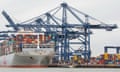 a huge container ship with a large blue crane in the background