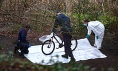 Forensic officers with a bike on a white plastic sheet.