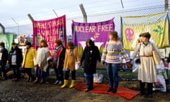 Peace protesters hold hands encircle perimeter fence American military aeroplane base Greenham Common in Berkshire.