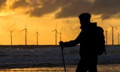 A female walker on Seaton Carew beach at sunrise, setting out on the 55km stretch of The England Coast Path. Seaton Carew, England. UK<br>E7MA2M A female walker on Seaton Carew beach at sunrise, setting out on the 55km stretch of The England Coast Path. Seaton Carew, England. UK