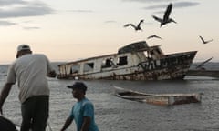 Fishers work next to a wrecked ship on the coast of Sucre, north-east Venezuela