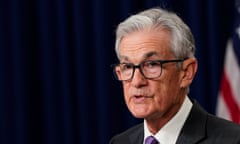 Man in dark suit and glasses at podium