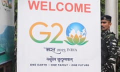 An Indian paramilitary soldier stands guard next to G20 meeting banner in Srinagar on 24 May.