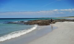 A girl among the rockpools on a beach