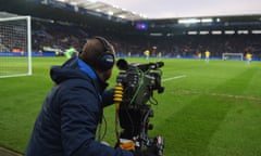 A camera operator at a live football match