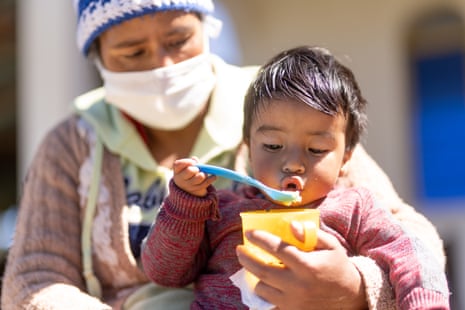 A child eats fruit delivered by Unicef and fortified with vitamins with his mother in a village in Guatemala last year.