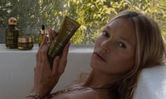 Kate Moss holding skincare product in a bath