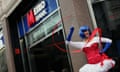 A street performer stands outside Metro Bank