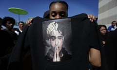 A fan holds a sweatshirt bearing an image of the murdered rapper at the public memorial service in Florida, 27 June 2018.