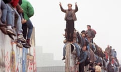 People celebrating on top of the dismantled Berlin Wall.