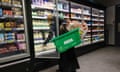 a shopper opens the chill fridge at Asda to grab some milk