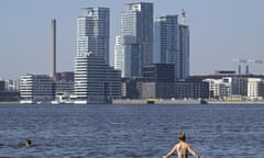 A woman standing in water with high-rise buildings in the background