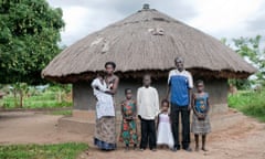 Eunice and Bosco with their family in front of their hut in Gulu, Uganda.