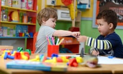 Two children colouring at a nursery school.