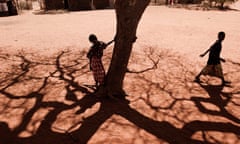 A boy stands next to a tree in Barmil.