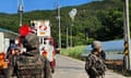 Balloons hang on electric wires as soldiers stand guard