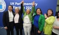 O'Neill McDonald hold Cullen's hands in the air as they stand at each side of her, while other party members clap and cheer