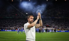 Gareth Southgate with his arms raised as he claps, standing alone on the pitch in a huge stadium