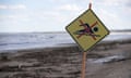 A no swimming warning at Old Bar Beach with high silt content from the recent floods, hay bales and dead livestock littering the beach east of Taree, Australia