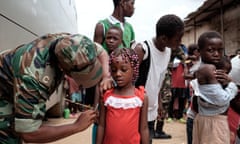 A Angolan military administers a yellow fever vaccine to a child at 'Quilometro 30' market, Luanda, Angola, 16 February 2016. This market in the Angolan capital was considered the center of the yellow fever outbreak killing 51 people out of 240 cases since December of 2015.