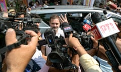 Indian National Congress (INC) party candidate Rahul Gandhi (C) shows his inked finger after casting his ballot at a polling station in New Delhi on 25 May