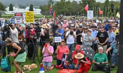 Protesters at the rally against renewable energy, with anti-lockdown red ensign flags and a sign referring to an alleged paedophile conspiracy in the background.