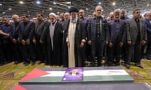 A handout picture provided by the Iranian supreme leader Ayatollah Ali Khamenei office shows him (C) leading the prayer, next to Iranian President Masoud Pezeshkian (C-R), over the coffin of late Hamas leader Ismail Haniyeh and his bodyguard during his funeral procession in Tehran