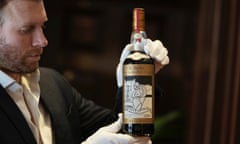 A bottle of the Macallan 1926 being shown by a man in gloves.