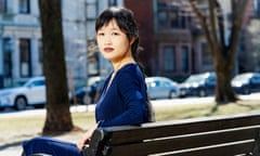 RF Kuang sits on a park bench in Boston, Massachusetts