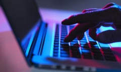 Silhouette of hand typing on laptop keyboard