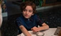 a boy smiling, seated at a dinner table