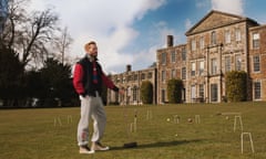 A model wearing Burberry clothes on a croquet lawn in front of a large house