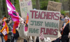 Striking teachers hold placards saying 'teachers just wanna have funds'.