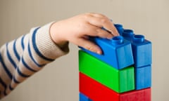 preschooler's arm playing with some colourful bricks