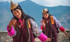 Bhutanese dancers against Himalayan backdrop.