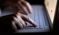 A man's hands type on a laptop