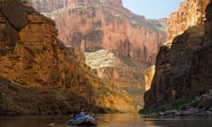 The Colorado River seen from Grand Canyon national park with people in a dingy in the foreground.