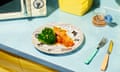 A retro-looking image of a counter top with a plate of salmon and broccoli, next to a microwave and period kitchen equipment
