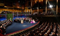 View from a balcony of people on stage and seated in an auditorium