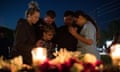 A group of people huddle and say a prayer after a vigil at Texas First Bank in Santa Fe.